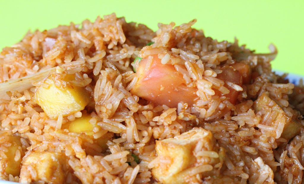 Mango Fried Rice · Fried rice with beds of mango, vegetables, egg, raisins, carrots, peas, and onions.