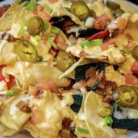 Loaded Nachos · Tri colored tortillas, house-made chili, cheese blend, tomato, green onions, jalapeño.