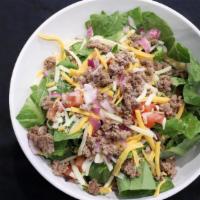Taco Salad · Romain on a bed of fresh tortilla chips, topped with taco beef, cheddar jack, diced tomatoes...