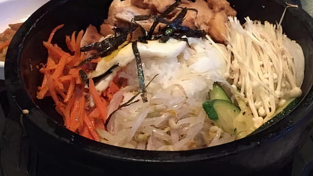 Dolsot Bibimbap / 돌솥 비빔밥 · Rice topped with carrots, zucchini, bean sprouts, shiitake mushrooms, radish, and a fried egg.