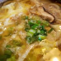 Nabe Udon / 우동 · Thick, wheat noodle soup with chicken, egg, and scallions in a hot pot.