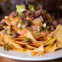 Macho Nachos · A manly stack of freshly made tortilla chips with mounds of melted cheese. Piled high with g...