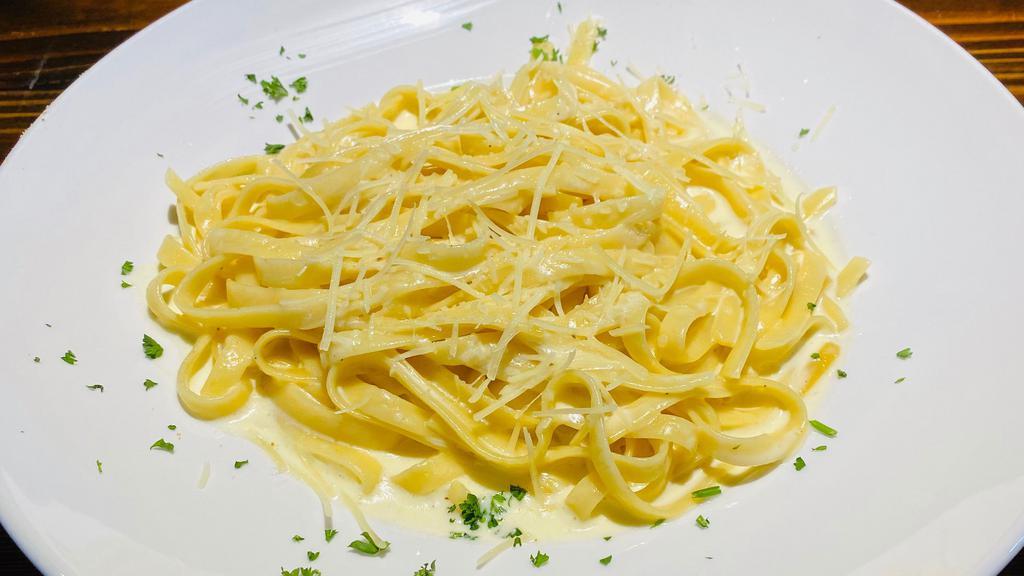 Fettuccine Alfredo · Fettuccine pasta tossen in a creamy alfredo sauce. Add chicken and shrimp for an additional charge. Your choice of soup or salad and garlic bread.