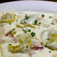 Ravioli Carbonara · Meat ravioli filled in a cream sauce with sauteed bacon. Your choice of soup or salad and ga...