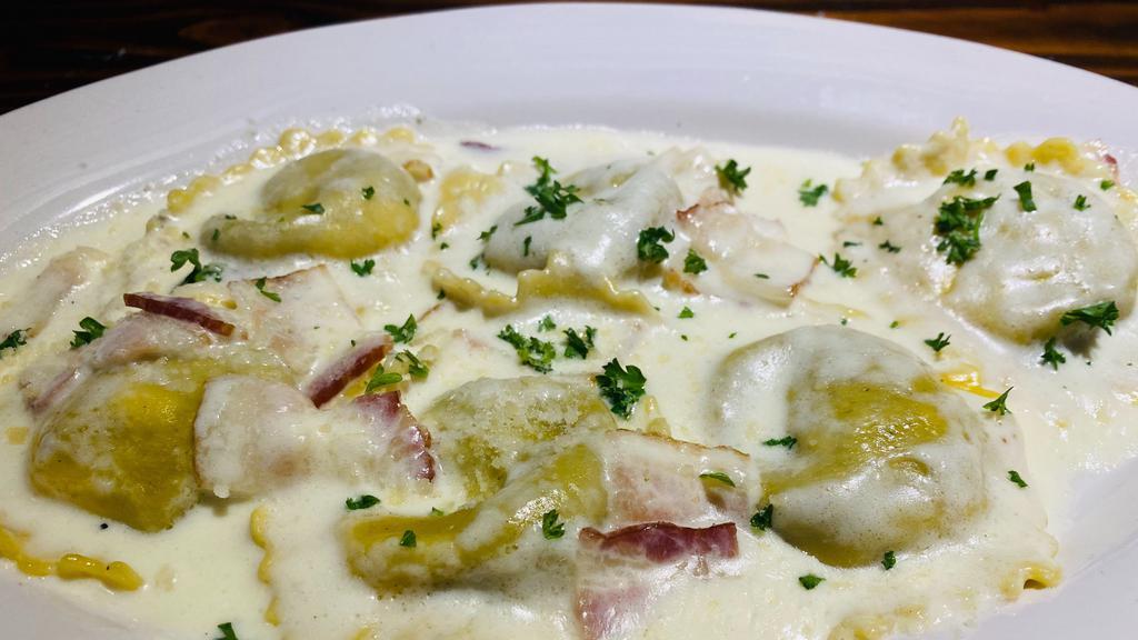 Ravioli Carbonara · Meat ravioli filled in a cream sauce with sauteed bacon. Your choice of soup or salad and garlic bread.