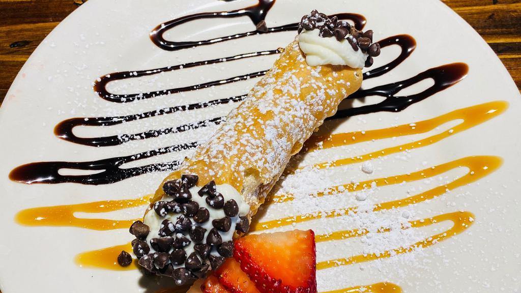 Cannoli · A crispy pastry shell filled with creamy ricotta and chocolate chips dusted with powdered sugar.