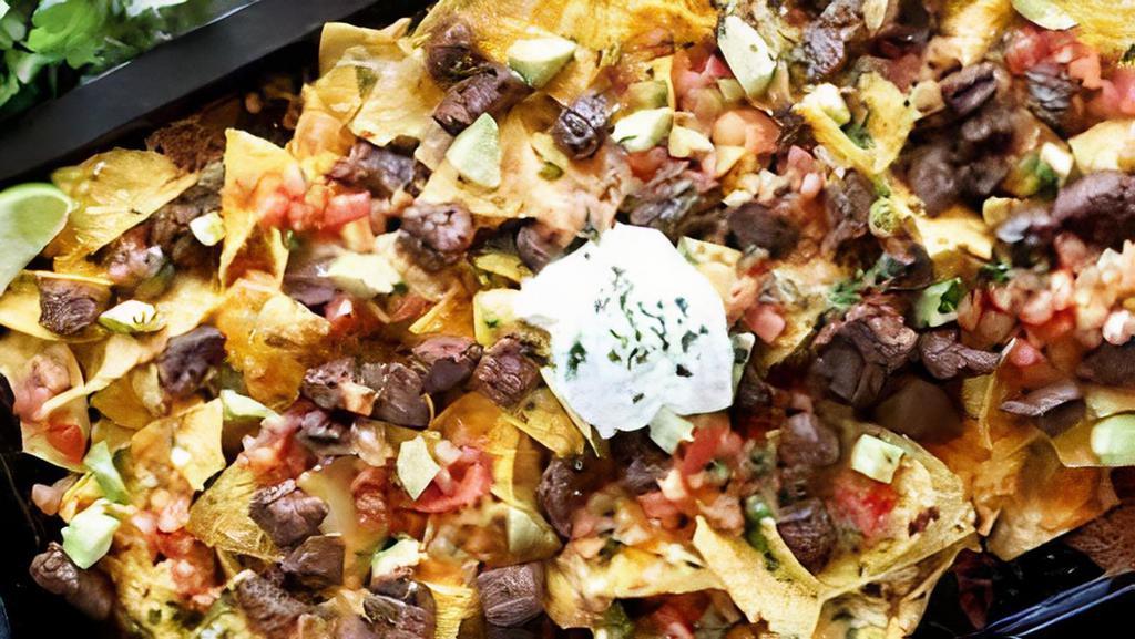Birria Nachos · Cheesy delicious loaded nachos topped with Birria

Made with: Lettuce, onion, cilantro, tomato, nacho cheese, shredded cheese, beans, and topped with chipotle mayo
