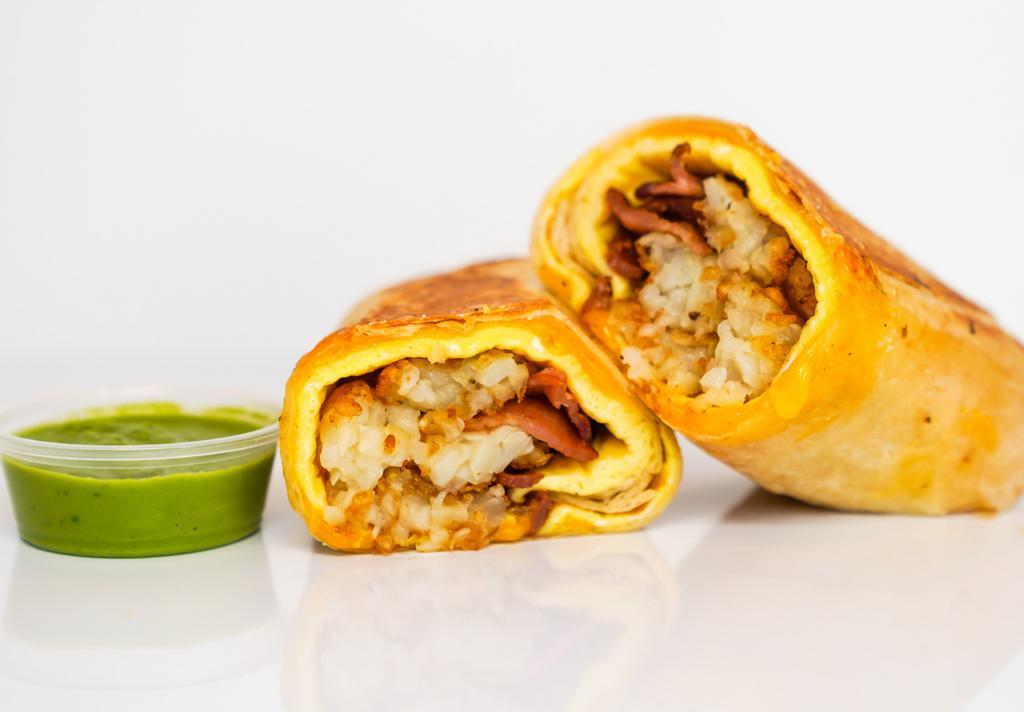 Turkey Bacon, Egg, & Cheddar Breakfast Burrito · 3 fresh cracked, cage-free scrambled eggs, melted Cheddar cheese, smokey turkey bacon, and crispy potato tots wrapped in a toasted 12” flour tortilla. Comes with avocado salsa verde side.
