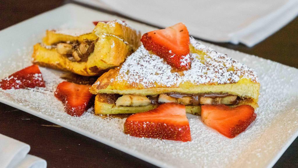 Nutella Stuffed French Toast · thick slices of french toast sandwiched together, stuffed with nutella and bananas then topped with fresh strawberries.