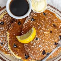 Blueberry Cornmeal Pancakes · Big triple stack made from scratch with local blueberries, served with butter, lemon, and re...