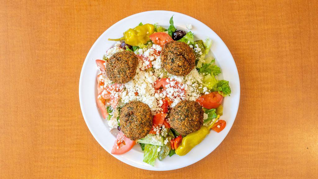 Falafel Salad · Falafel served on top a mix of green leaf and romaine lettuce, tomatoes, onions, cucumbers, bell peppers, feta cheese, pepperoncini, olives and greek dressing with a side of tahini and hot sauce.