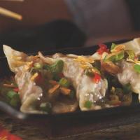 Beef & Ginger Potstickers · Pan-seared potstickers topped with pickled vegetables, green & crispy onions, and soy sauce