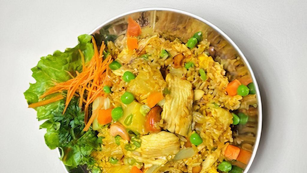 Pineapple Fried Rice · Stir-fried with rice, egg, pineapple,  onion, raisin, cashew nut, pea, carrot, and curry powder .