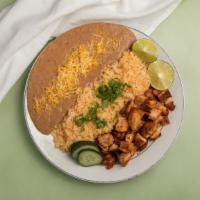 Pastor Bean & Rice Plate · Pastor style chicken with beans, rice, green sauce, and red sauce on the side.