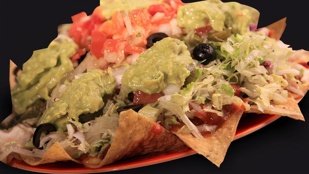 Nachos · Crispy tortilla chips topped with beans, nacho cheese, choice of meat, lettuce, sour cream, salsa, tomatoes, jalapeno and avocado.