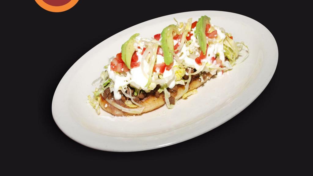 Huarache · Long tortilla that is deep fried, topped with beans, choice of meat, lettuce, sour cream, salsa, cheese, tomatoes, and avocado.