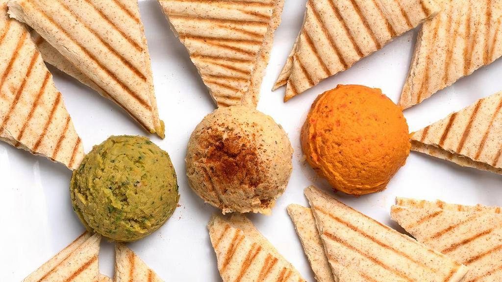 Hummus Trio · Our housemade Roasted Garlic, Spicy Avocado Hummus, and Roasted Red Pepper Hummus. Served with wedges of warm pita bread or slices of carrots and celery.