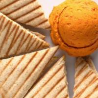Roasted Red Pepper Hummus · Roasted red peppers blended with chickpeas, herbs, and spices. Served with wedges of warm pi...