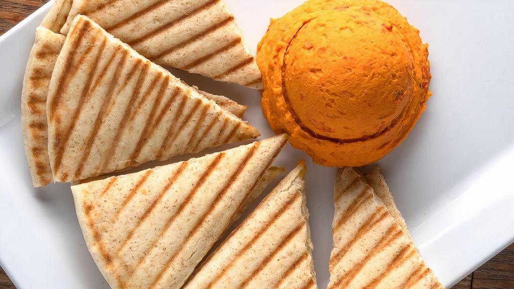 Roasted Red Pepper Hummus · Roasted red peppers blended with chickpeas, herbs, and spices. Served with wedges of warm pita bread or slices of carrots and celery.