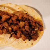Taco Al Pastor · Three open face corn tortillas with grilled pork and pineapple seasoned with al pastor seaso...