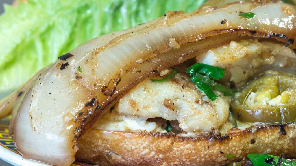 Alaskan Cod · Delectable pan-seared fish in garlic tapenade, fresh cilantro, pickled jalapenos, caramelized onions, and crisp romaine all on a toasted baguette slathered with garlic aioli.