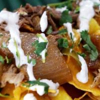 Caribbean Roast Nachos · Tortilla chips topped with cheese, roasted pork, pineapple, caramelized onions, jalapenos, s...
