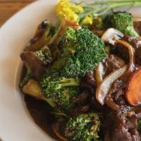 Beef Broccoli · Beef sauteed with broccoli, white onions, and carrots in a light garlic sauce. Served with w...