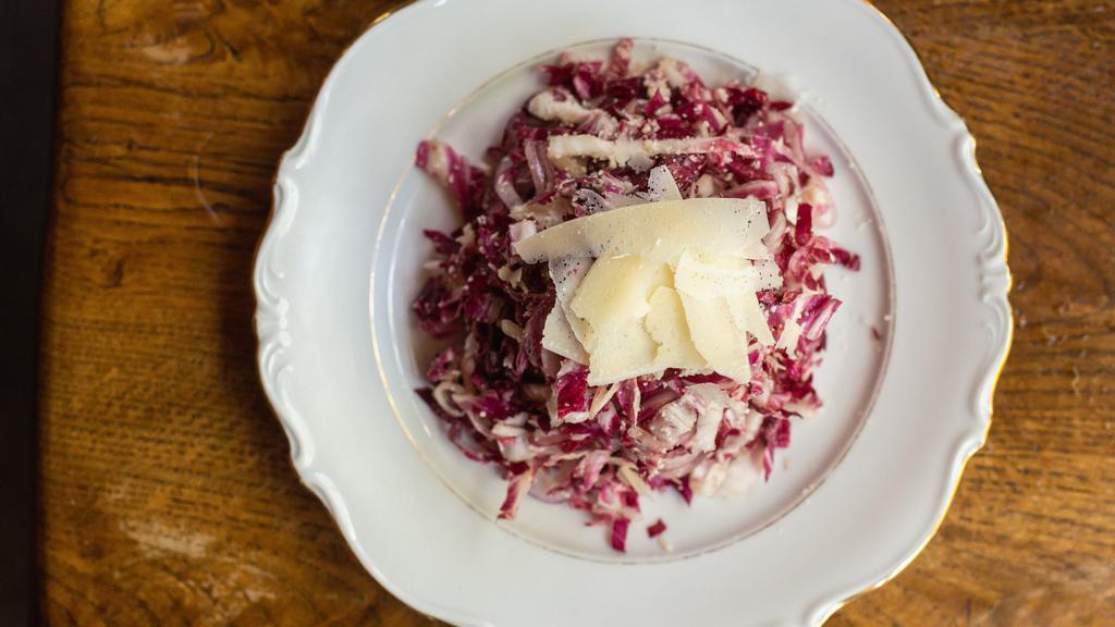 Radicchio Salad · Thinly sliced radicchio with red onions, tossed in a red wine vinaigrette, topped off with Grana Padano.  Vegan upon request.
