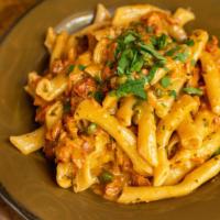 Penne Al Salmone · Local old-smoked wild salmon, garden peas, tomatoes and cream, flamed with vodka, and tossed...