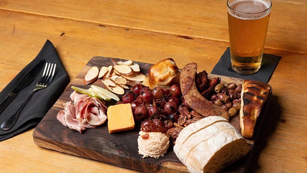 Combo Board · bacon confit, house-cured ham, fennel sausage, brie en croute, aged cheddar, tomato goat cheese. served with an assortment of house-baked breads, crackers, grilled grapes, sliced apples, nuts & olives