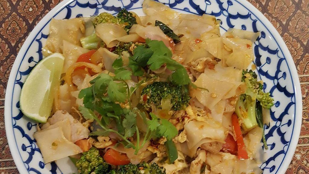 #64 Pad-Kee-Mow · Drunken noodle. Stir-fried wide rice noodle with Thai chili sauce, egg, garlic, tomato, yellow onion, basil, jalapeno, bell pepper, broccoli, and cilantro on top.