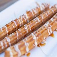 Churros · Deep-fried fritter rolled in cinnamon sugar, served with caramel, whipped cream, and vanilla...