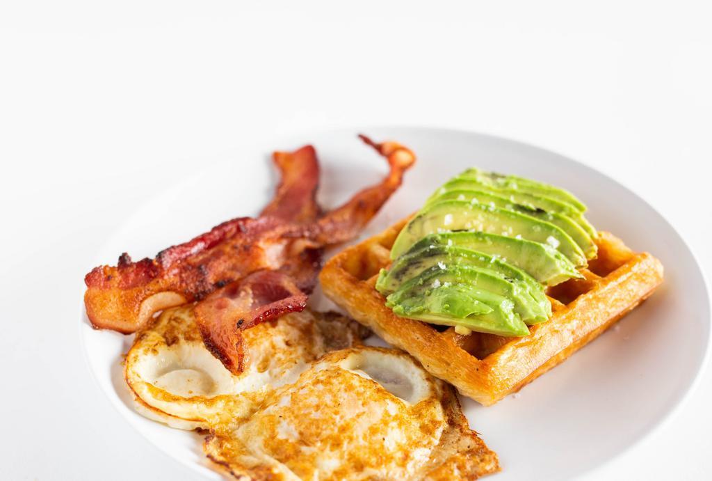 Breakfast Plate · Two eggs, two slices of bacon, sliced avocado and a croissant waffle.