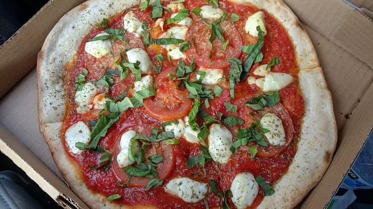 Margherita Pizza · Tomato sauce, fresh roma tomatoes, fresh basil, and fresh mozzarella.