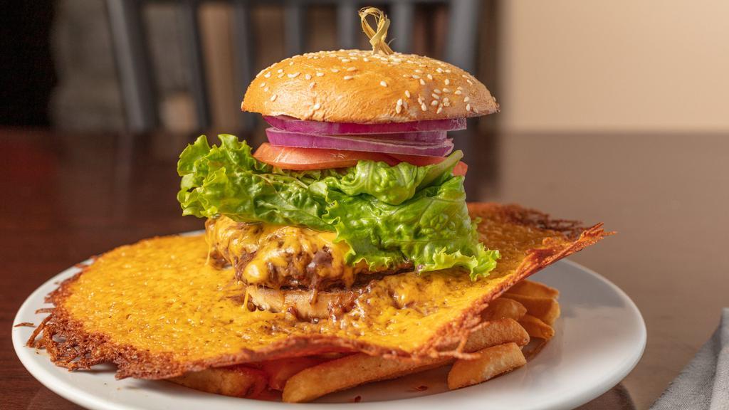 Cheddar-Halo-Cheeseburger · Half a pound of ground sirloin surrounded by a caramelized cheddar cracker with lettuce, tomato, onion and pickles.