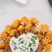 Tater Tot Skillet · Venezuelan shredded steak, crispy tater tots, melted Cheddar cheese, and avocado, topped wit...