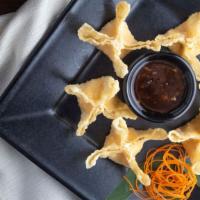 Crispy Crab Wontons · Golden wontons filled with crab and cream cheese, delicately seasoned and served with an ora...