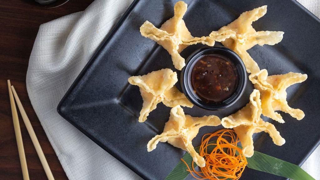 Crispy Crab Wontons · Golden wontons filled with crab and cream cheese, delicately seasoned and served with an orange-pineapple vinaigrette.