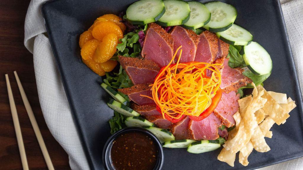 Seared Tuna Tataki Salad · Seared sashimi grade tuna over a bed of crisp mixed greens served with cucumbers, crispy wontons, with soy ginger dressing.