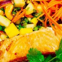 Grilled Salmon With Thai Mango Salad · Perfectly grilled flaky pink salmon topped with house salad mixed of green mango, red and gr...