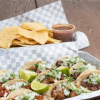 The Party House · Nine street tacos box, three asada, three pastors, three chicken with cilantro, onions, chip...