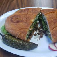 Torta · Your choice of meat, topped with mayo, onions, cilantro, jalapeños, lettuce, tomato, & Guaca...