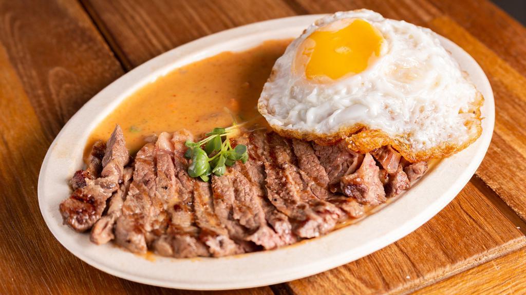 Grilled Premium Angus Ribeye With Rice · grilled Angus premium ribeye steak, fried egg, choose between green curry sauce or panang curry sauce
