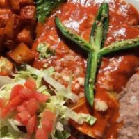 Enchiladas Michoacanas · 3 cheese enchiladas with carnitas, served with beans and potatoes, topped with lettuce, toma...