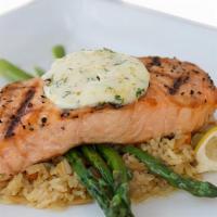 Grilled Atlantic Salmon · Broiled salmon filet topped with citrus butter on a bed of rice pilaf and served with grille...