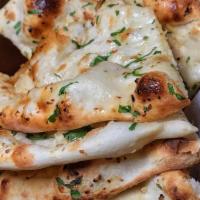 Garlic Naan · Warm soft, puffy bread bakes in a special tandoor (clay oven) with fresh garlic & butter on ...