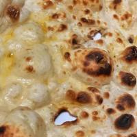 Butter Naan · Warm soft, puffy bread bakes in a special tandoor (clay oven) with butter on top. Vegetarian.