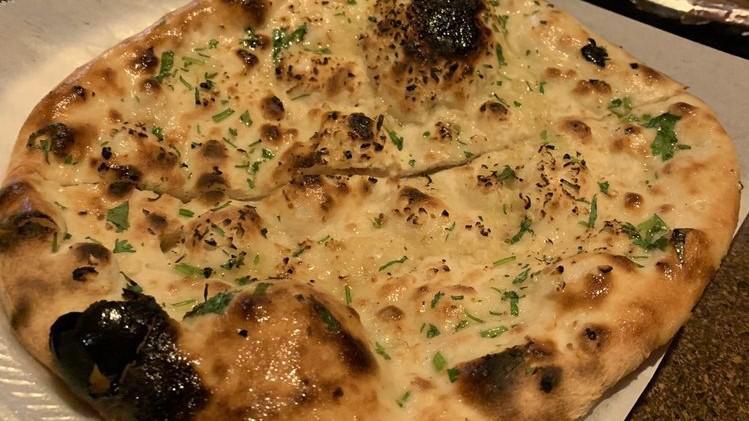 Garlic Naan · Fresh Naan garnished with freshly chopped garlic and baked to perfection.