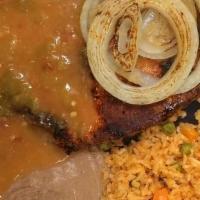 Carne Adobada · Flavorful pork steak marinated in a tangy red chile sauce and smothered in green chile. Serv...