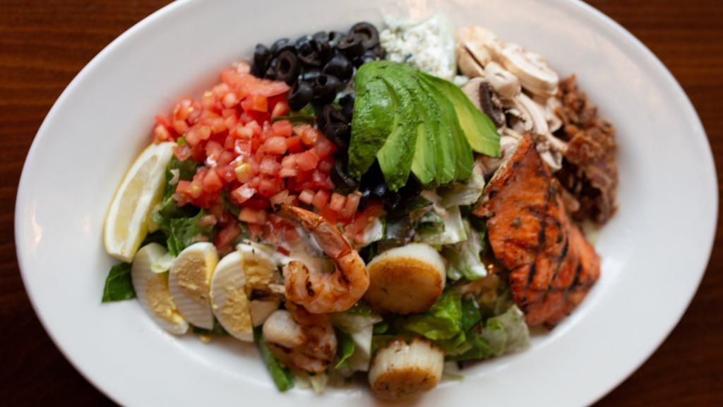 Big Fish Cobb · Gluten free. Seared scallops, grilled prawns, grilled wild salmon, bacon, mushrooms, olives, eggs, tomatoes, avocado, blue cheese, balsamic vinaigrette, blue cheese dressing.
